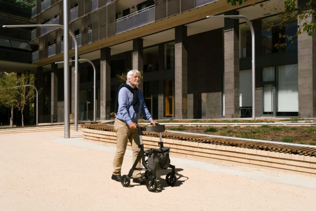 Man går på plads med sin aluminiums letvægts rollator med smart taske